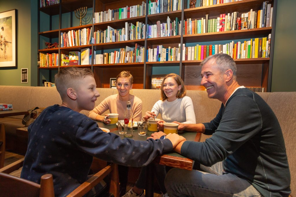 Familie sitzt in der Bibliothek im Schulz Hotel Berlin Ostbahnhof